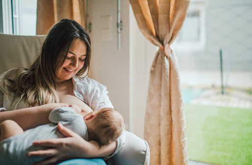 Mutter stillt ihr Baby auf dem Sofa