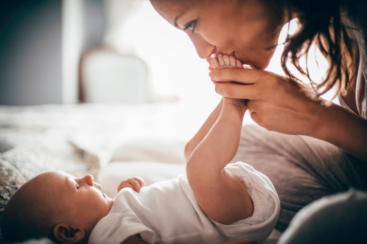 Mother kissing babys feet