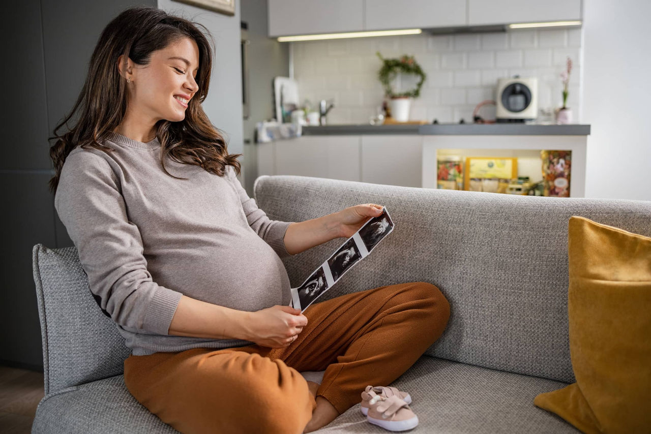 Aptaclub Schwangere Frau hält Ultraschallbilder