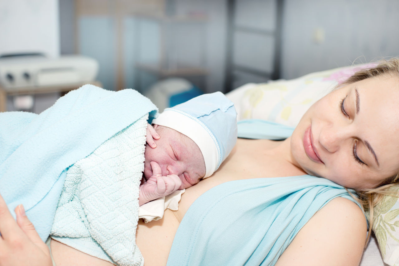 Mutter hält Neugeborenes im Spital