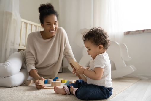Mutter und Baby spielen im Kinderzimmer