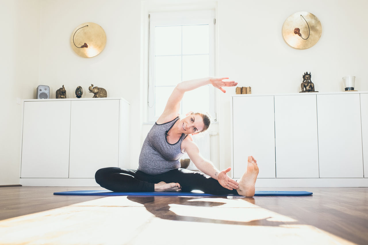 Schwangere Frau mit Yogamatte